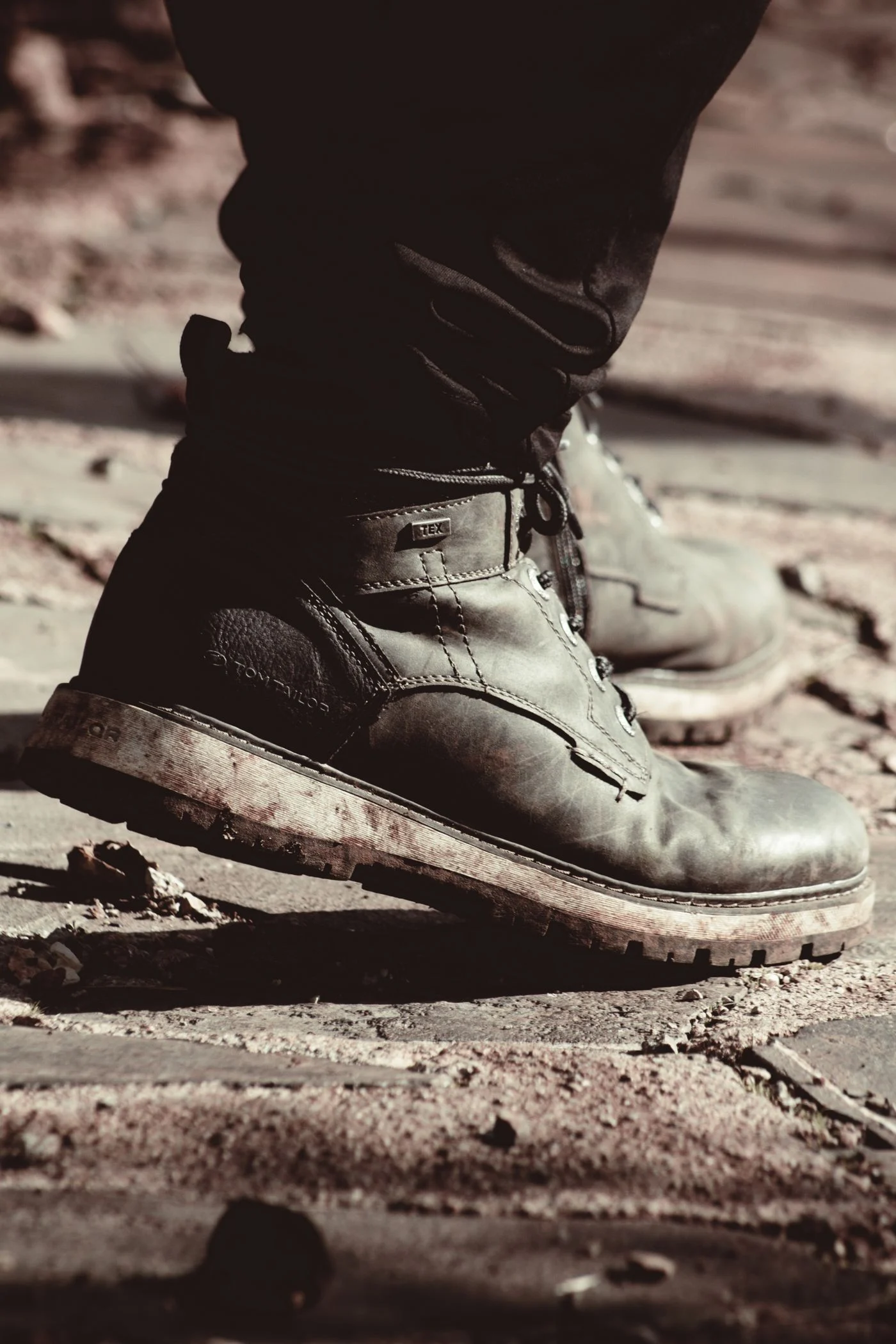 Well-worn leather work boots covered in dust
