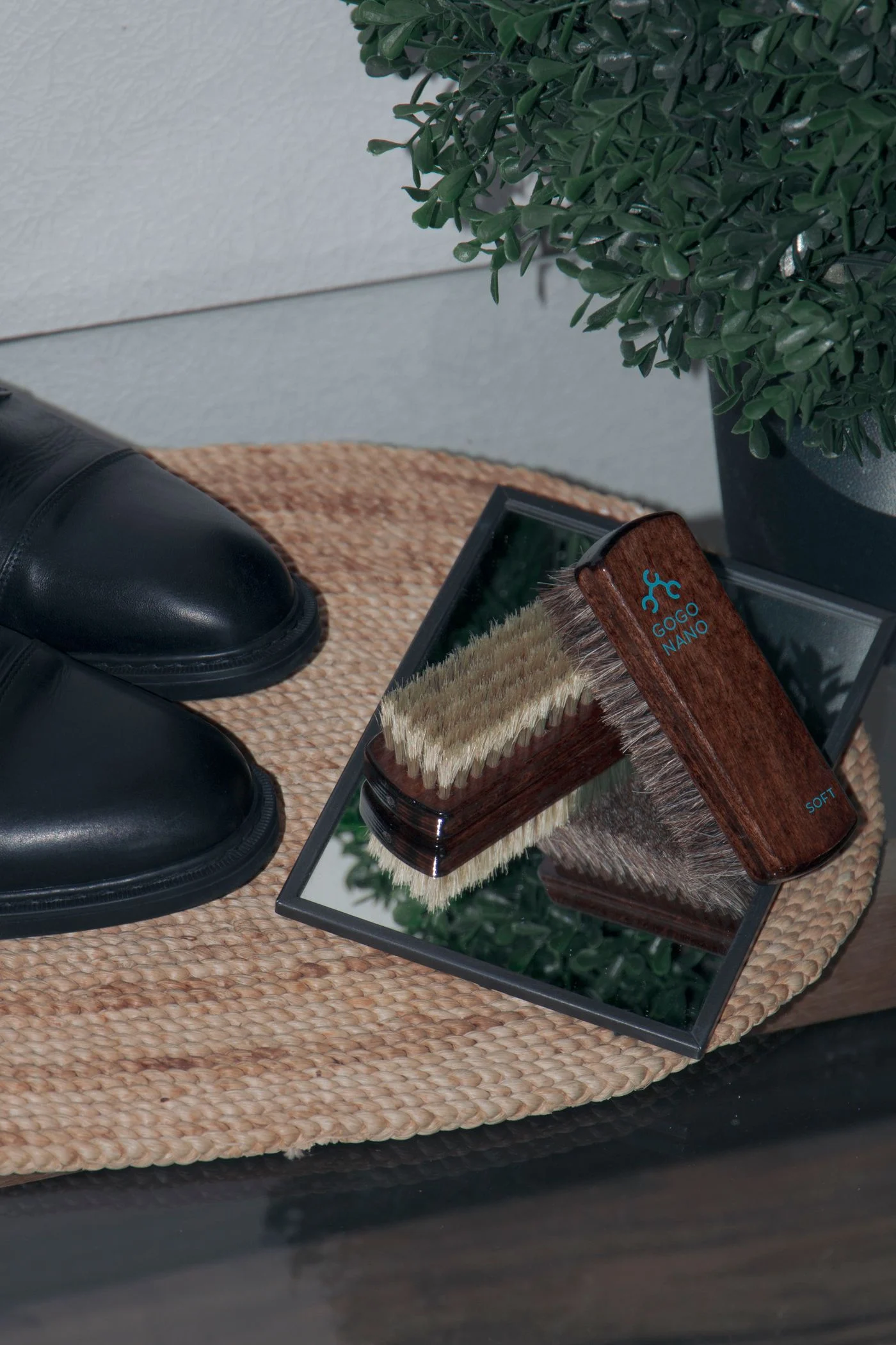 Black leather shoes beside a horsehair shoe brush